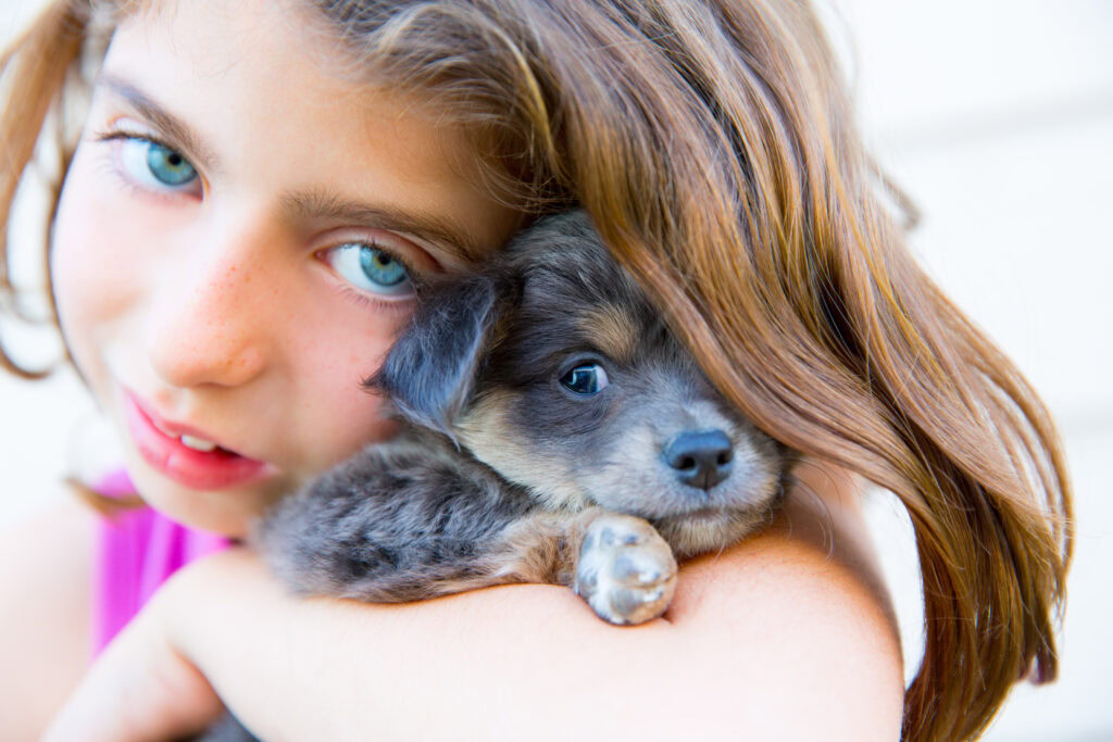 young girl hold a small puppy